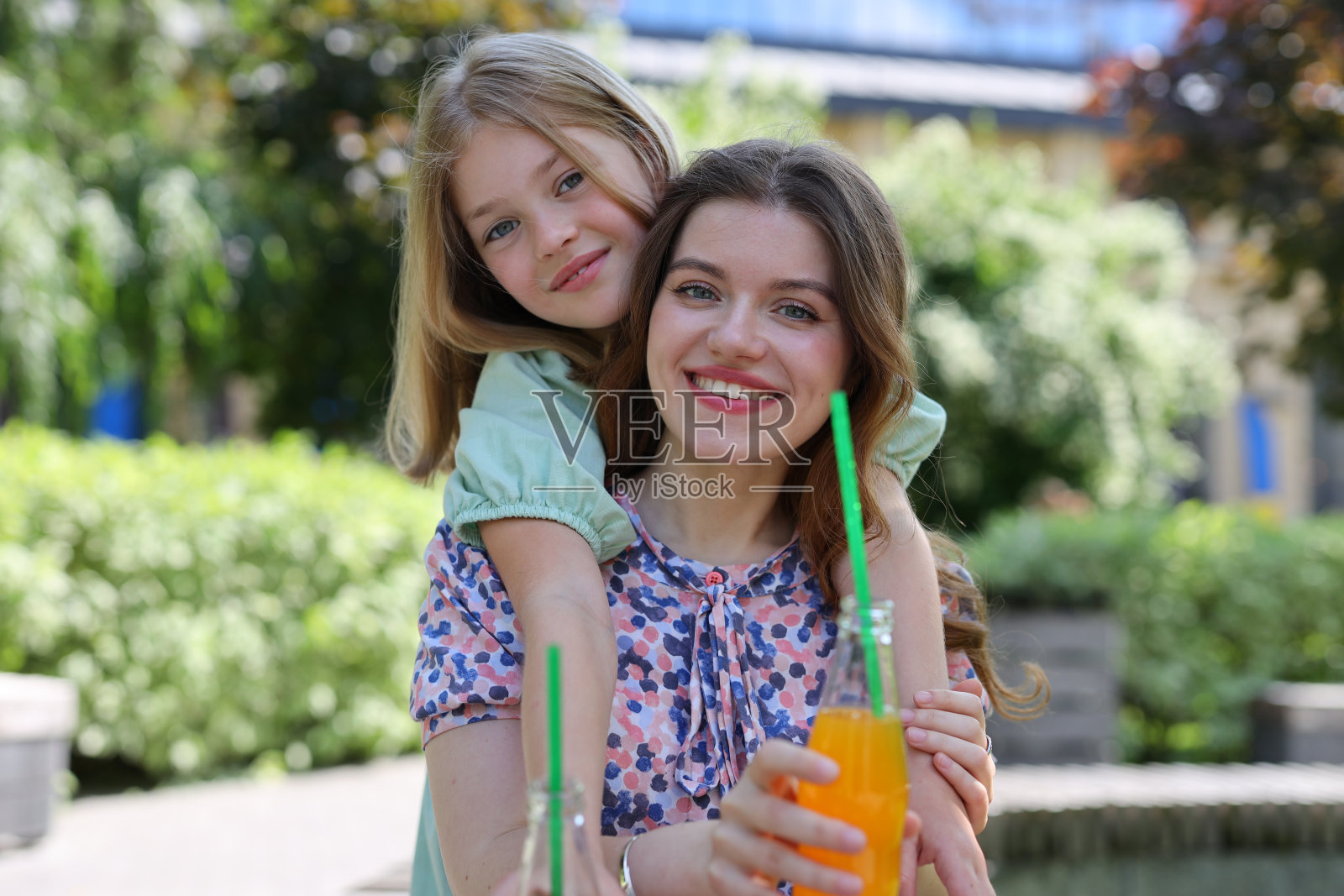 一对幸福的母女在公园里温暖地拥抱，一起散发着爱和欢乐。照片摄影图片