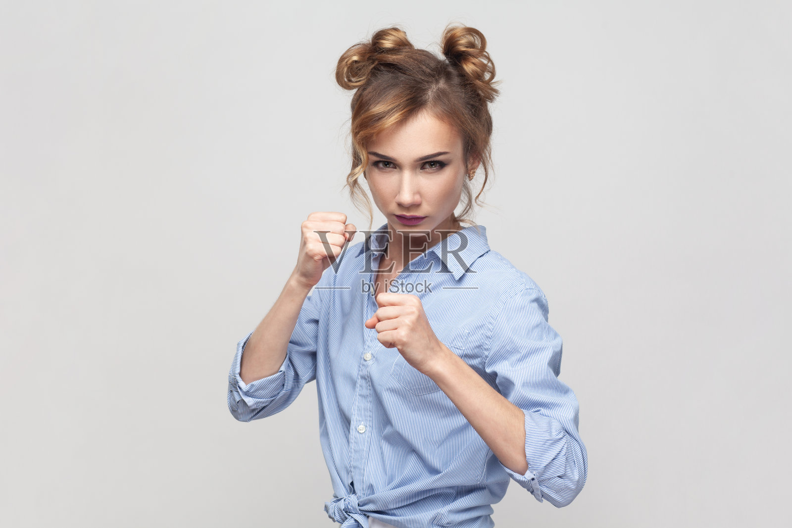 看起来严肃而自信的女人紧握着拳头在她面前为自己辩护。照片摄影图片