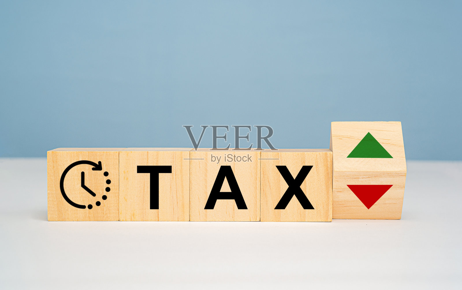 带有VAT和时间图标的木制立方体，以及大理石桌子上带有上下箭头的木制立方体照片摄影图片