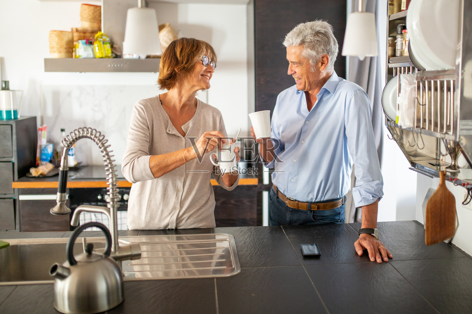 老夫妇端着咖啡在厨房微笑照片摄影图片