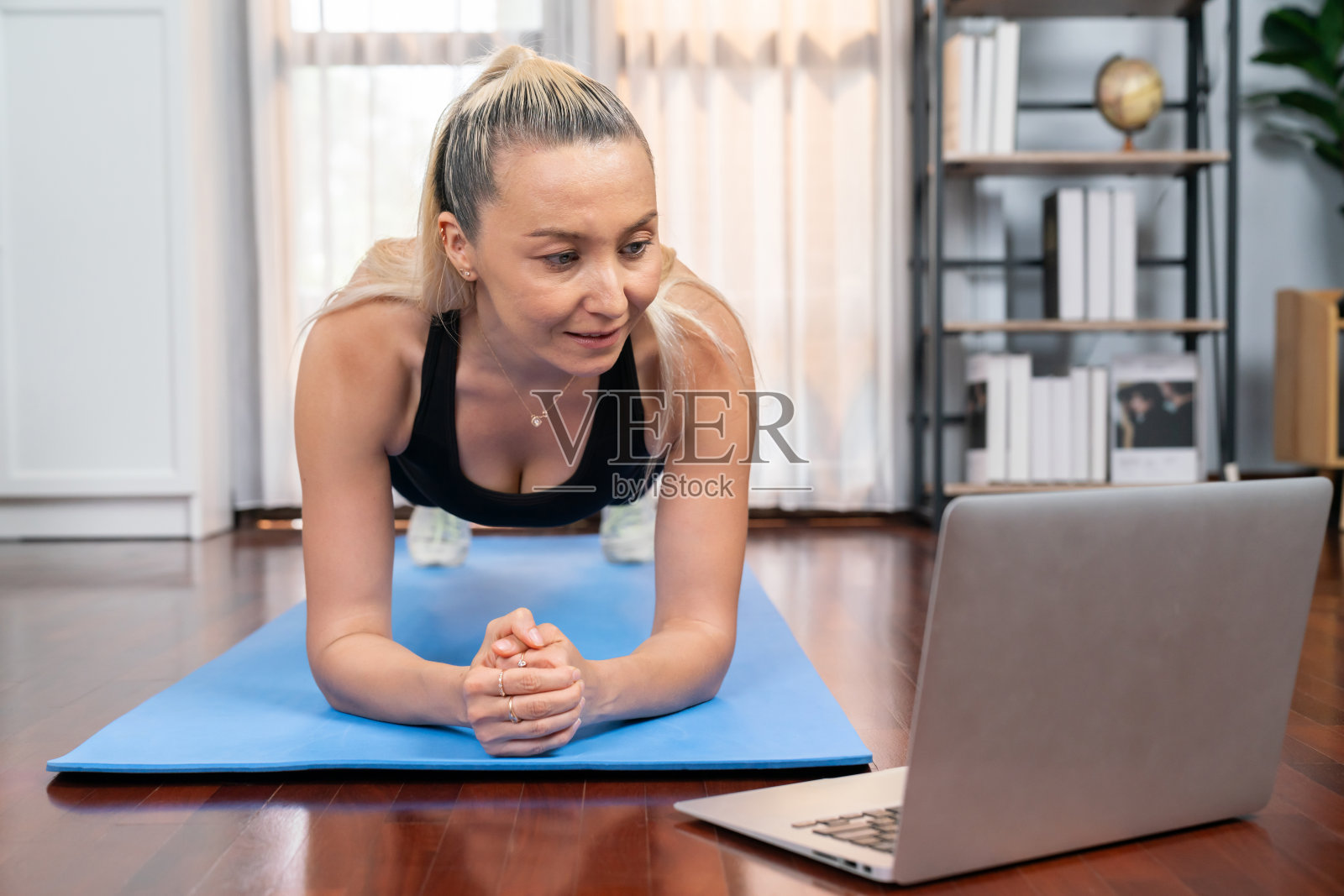 运动和运动的高级女子在家里的健身垫上平板支撑。影响力照片摄影图片