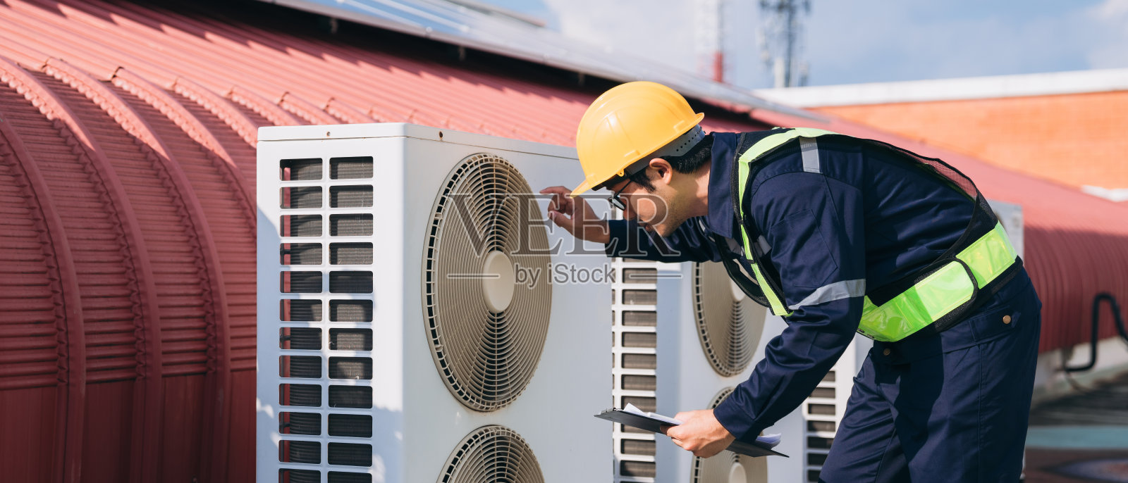 工程师正在检查一幢主要建筑或工业设施的空调冷却系统。照片摄影图片