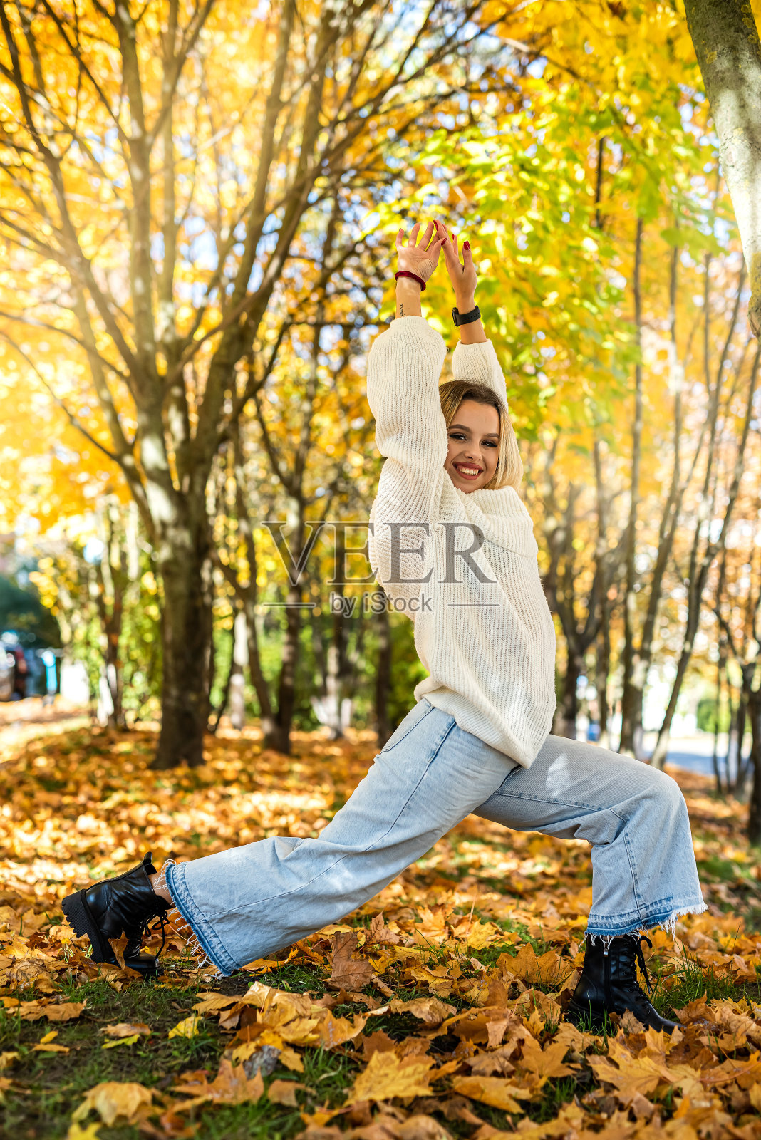 微笑的年轻女子在秋天的公园享受阳光明媚的天气照片摄影图片