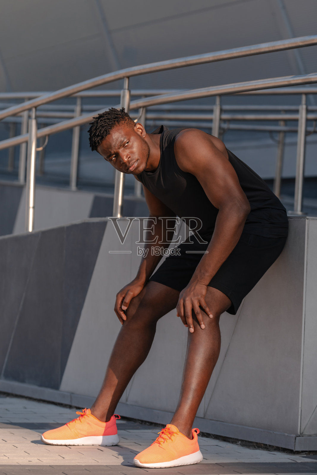 穿着运动服的疲惫的非洲男子在户外剧烈运动训练后休息的全身照片照片摄影图片