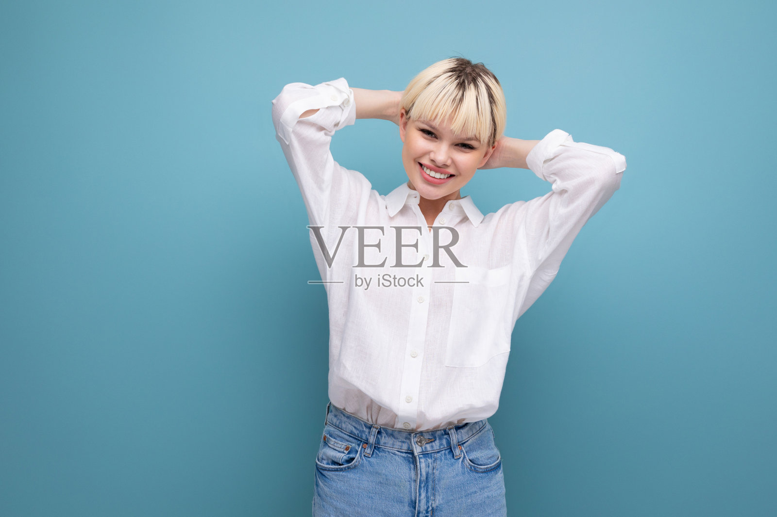 年轻可爱的金发时尚女子，短发，穿着白衬衫和牛仔裤。休闲装概念照片摄影图片