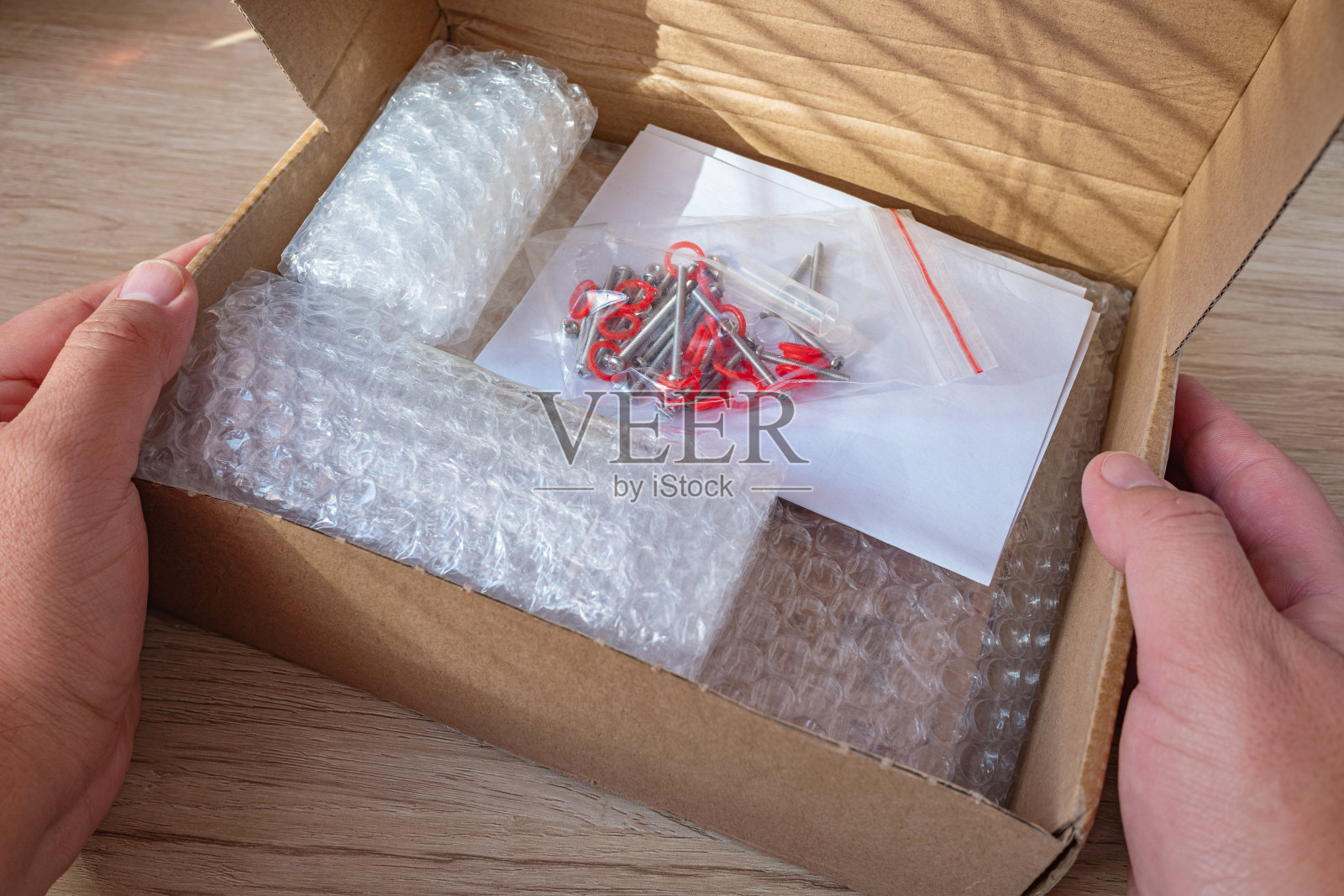 一名男子打开一个装有组装工具的盒子。照片摄影图片