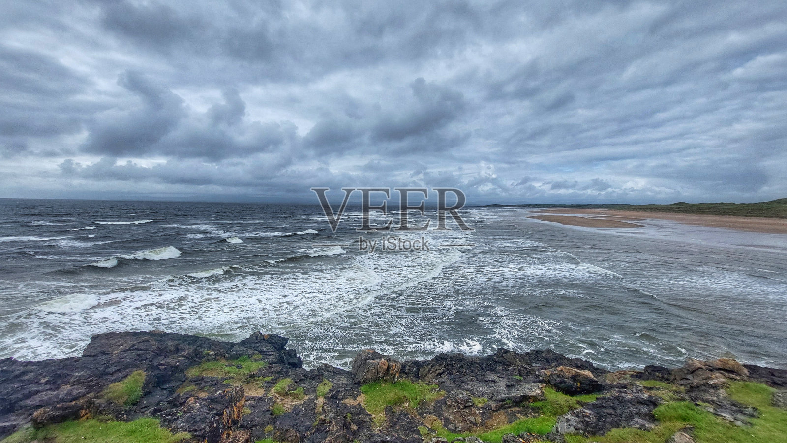 爱尔兰风景:郁郁葱葱的乡村靠近大海和威胁的天空照片摄影图片
