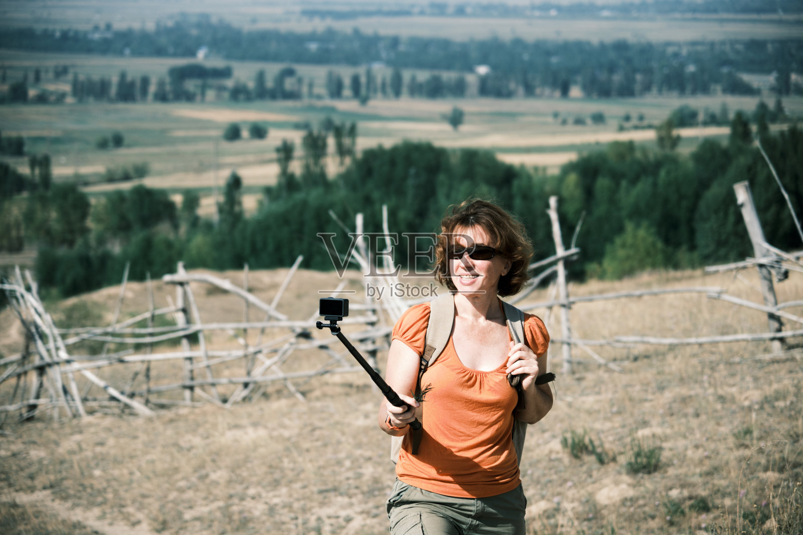快乐的女游客在山麓徒步旅行，她的徒步旅行流照片摄影图片