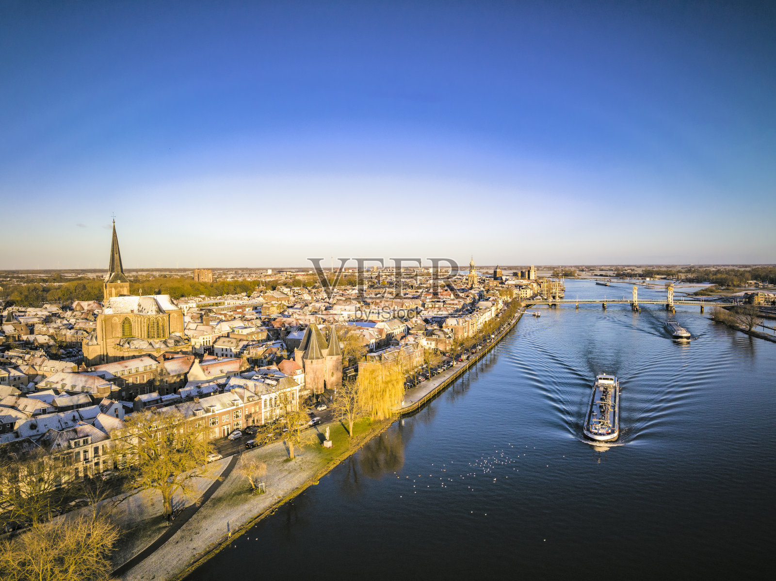 在寒冷的冬季日出时，在坎彭市的货船驳船上观看艾塞尔河照片摄影图片