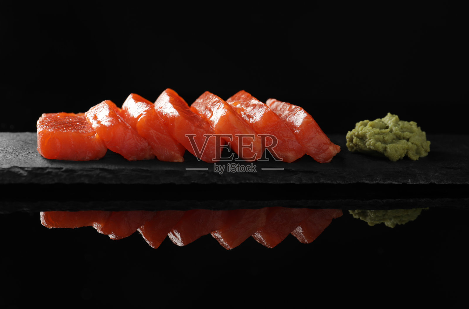 美味的三文鱼生鱼片和芥末在黑色镜面照片摄影图片