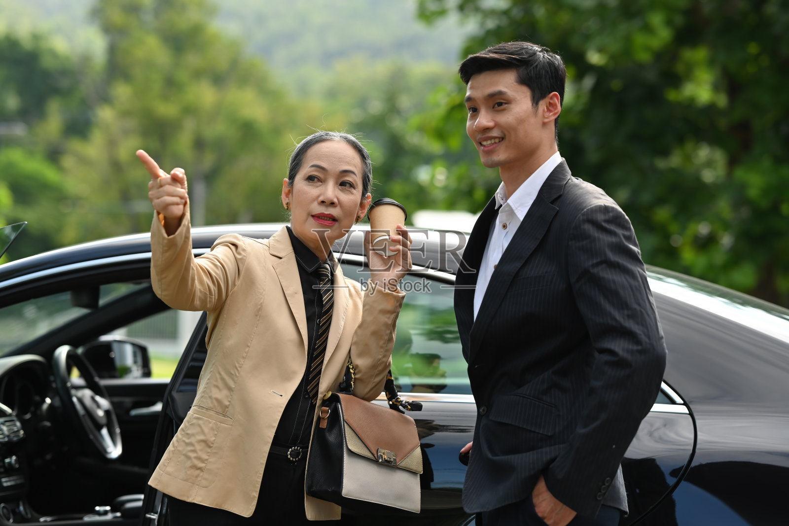 老年女商人下车后与伴侣谈话的肖像照片摄影图片