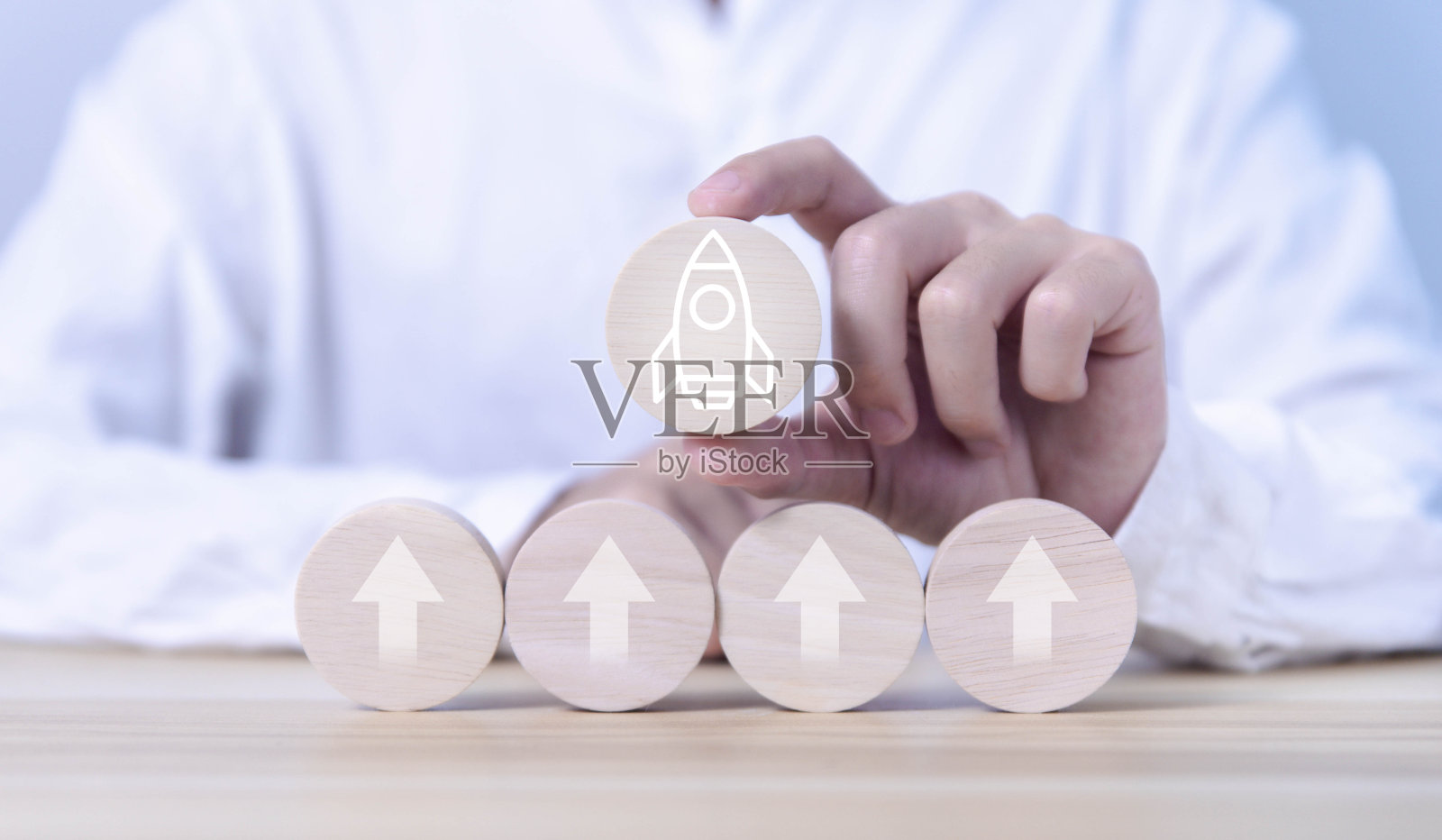 启动业务图标和箭头在木块上增加。照片摄影图片