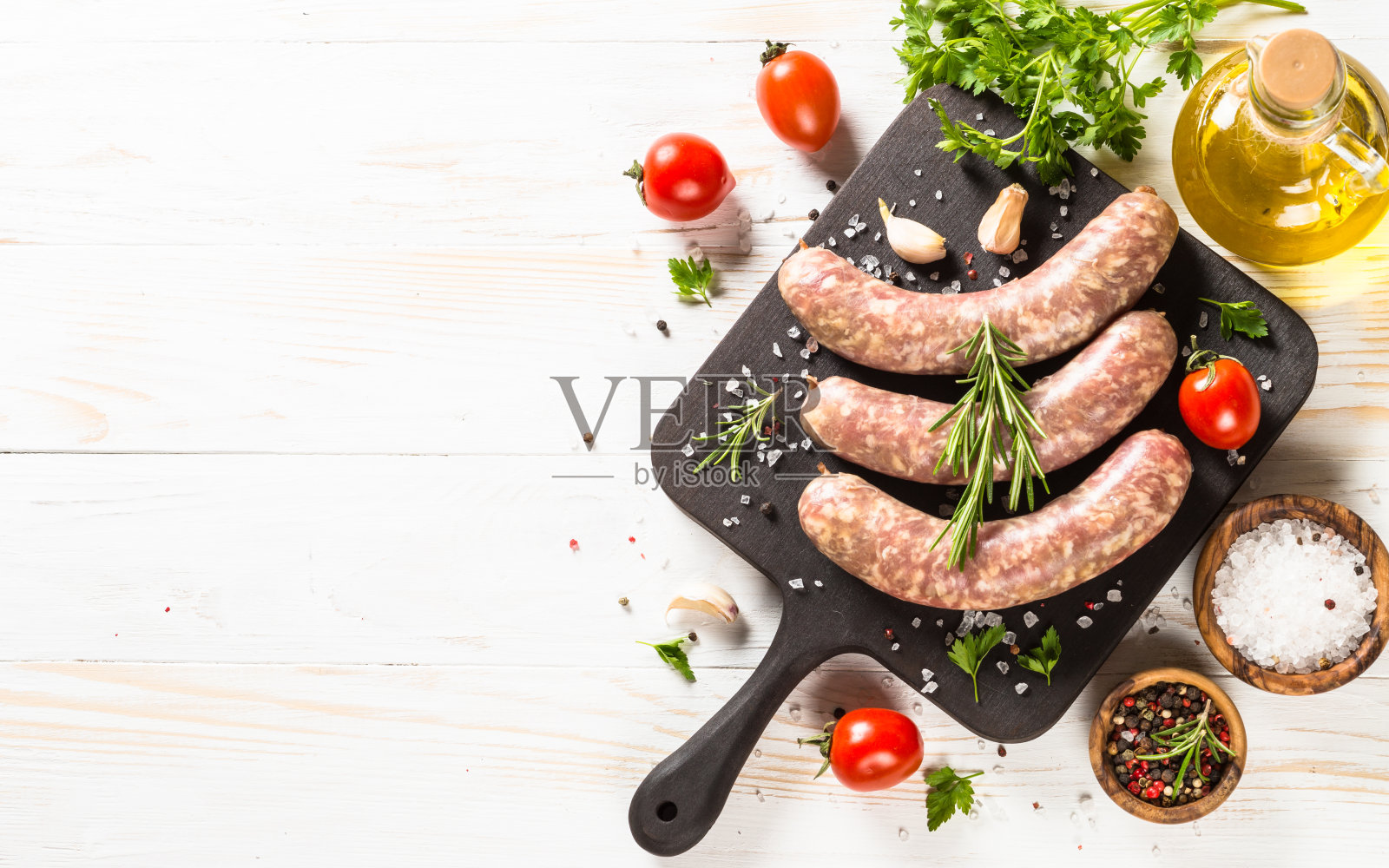 白木桌上的切菜板上放着小香肠或香肠。照片摄影图片