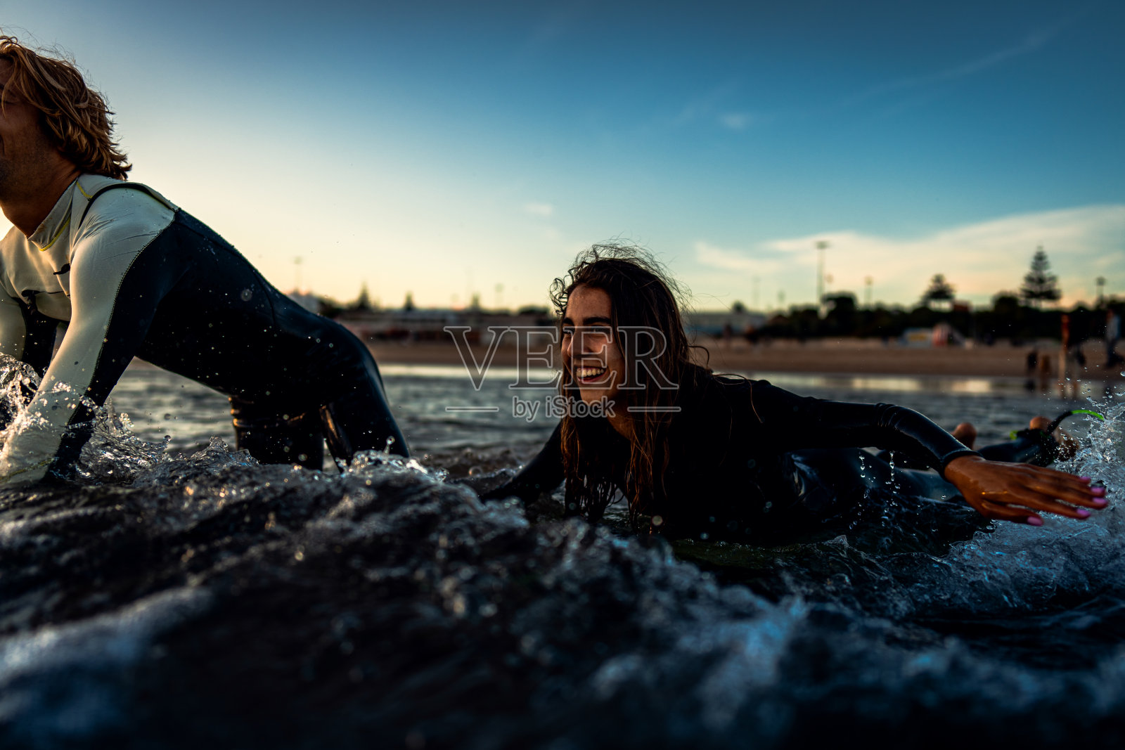 两个冲浪者带着冲浪板在海滩上行走，准备冲浪。照片摄影图片