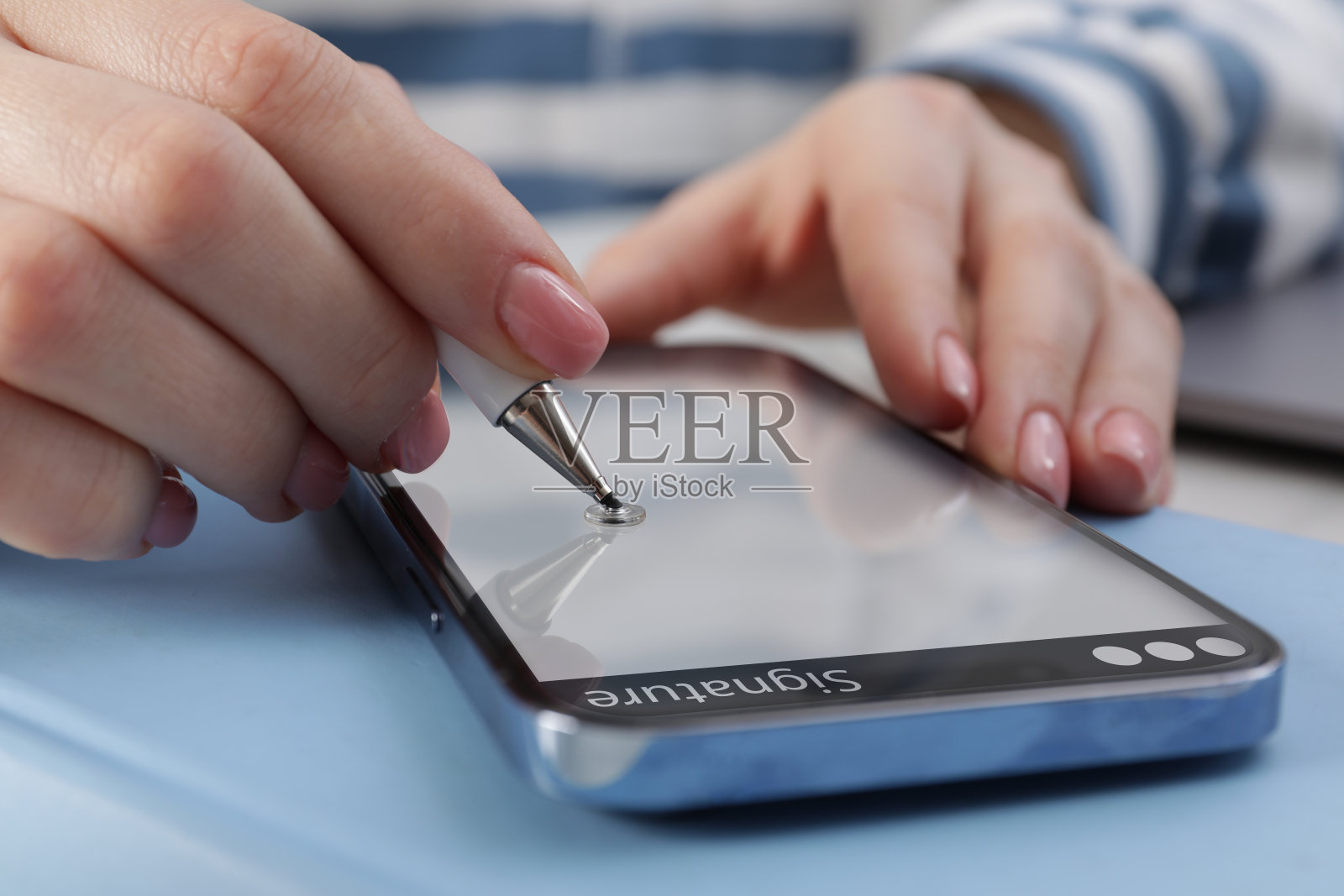 电子签名。妇女使用手写笔和手机，特写照片摄影图片
