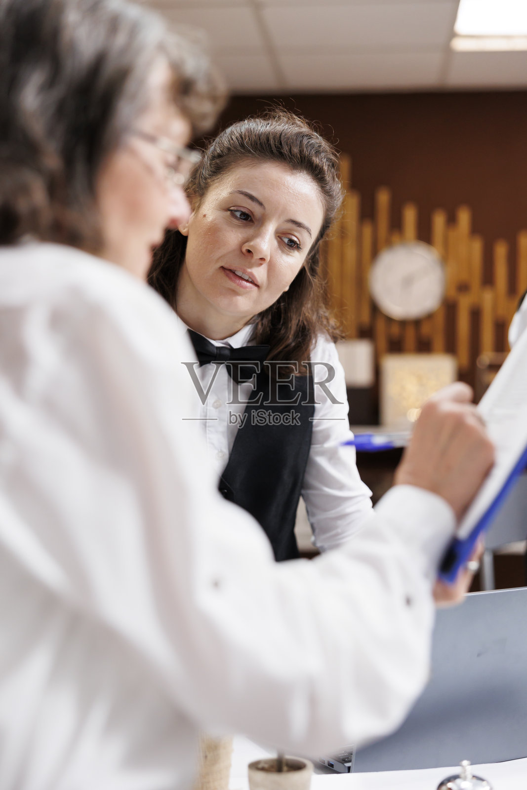 老妇人在酒店前台办理入住手续照片摄影图片