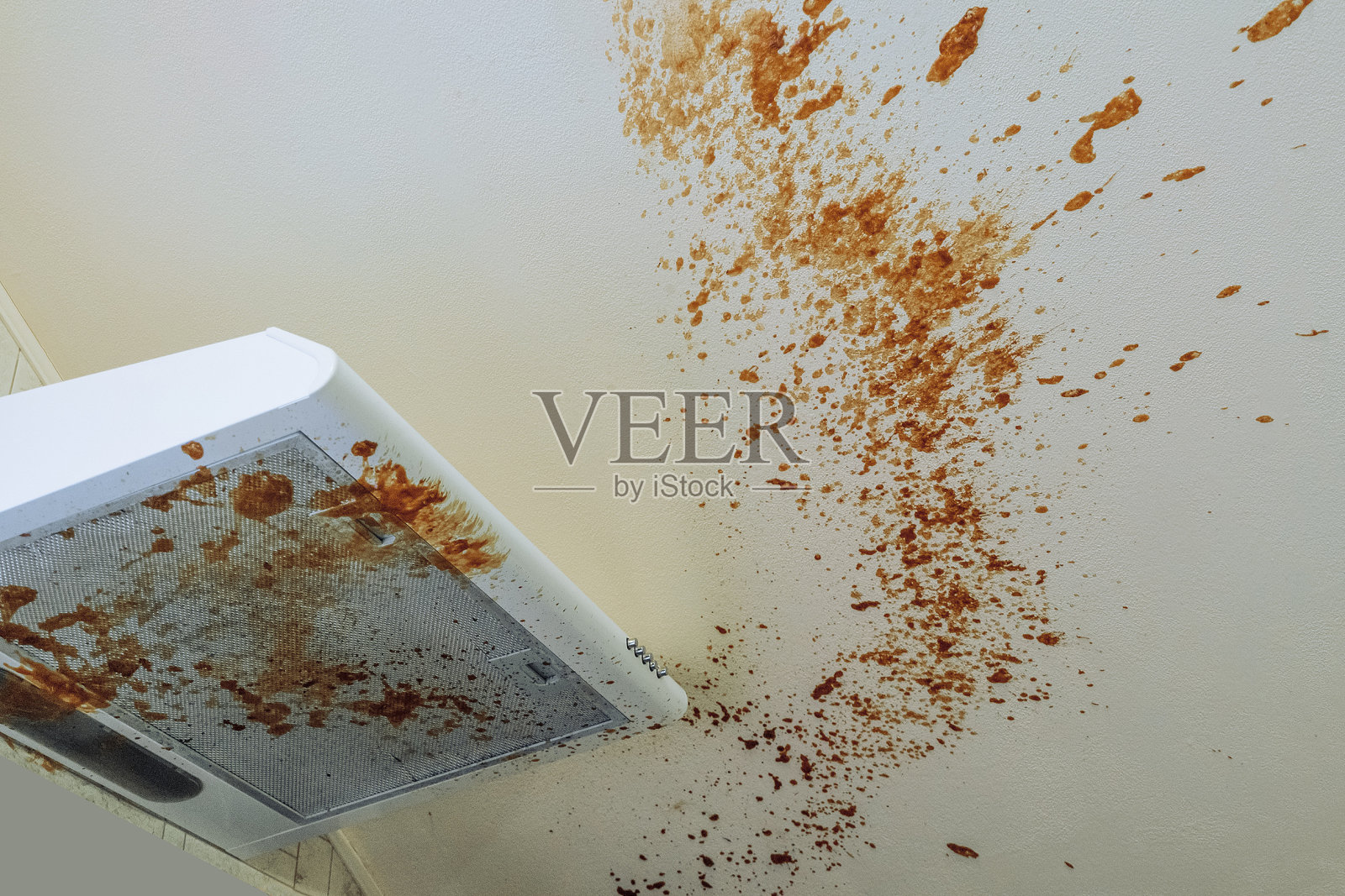 肮脏的厨房。热锡罐爆炸后，厨房罩和天花板表面有煮沸的炼乳。照片摄影图片