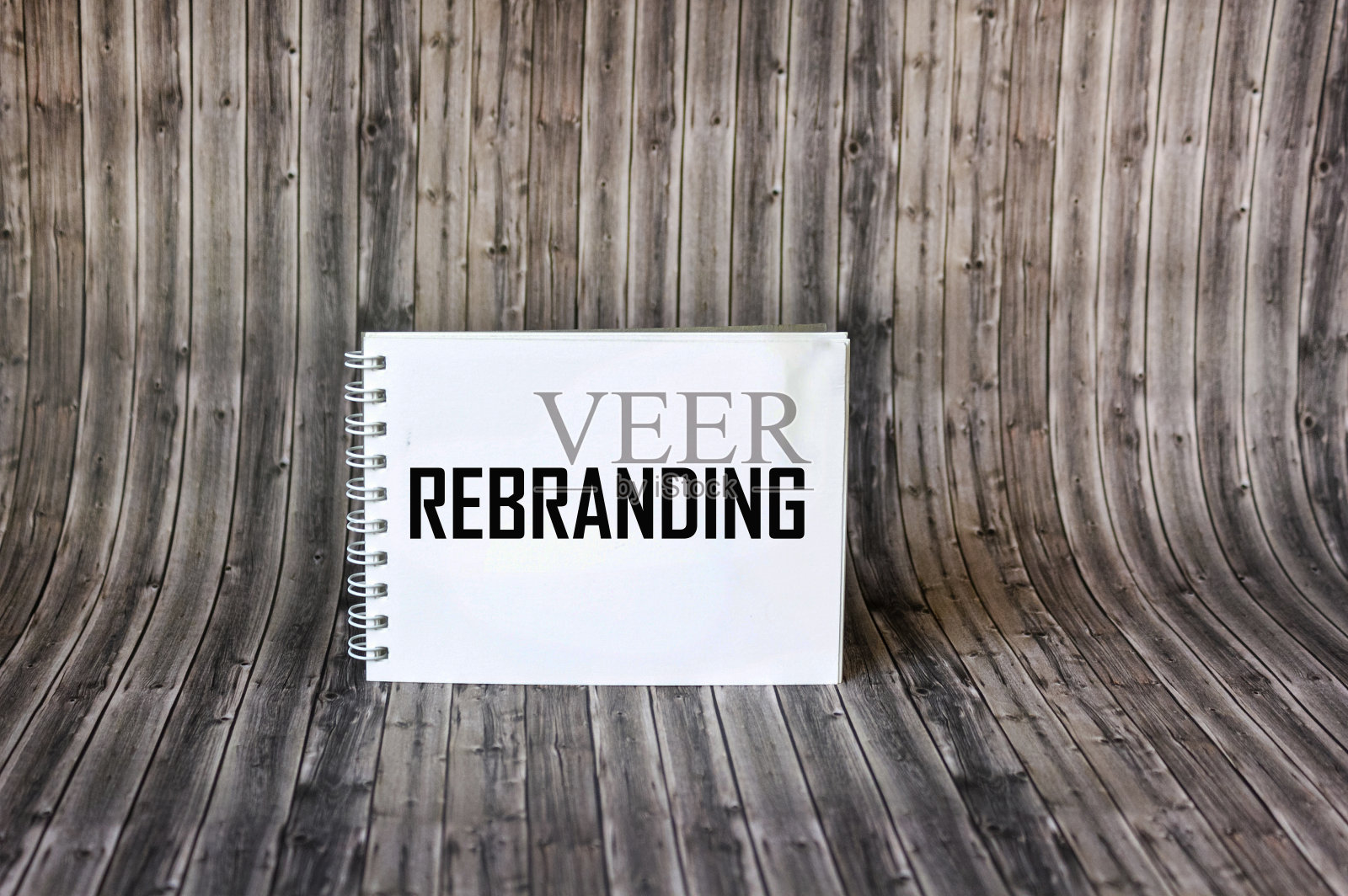 在记事本和木制背景上的单词REBRANDING。照片摄影图片