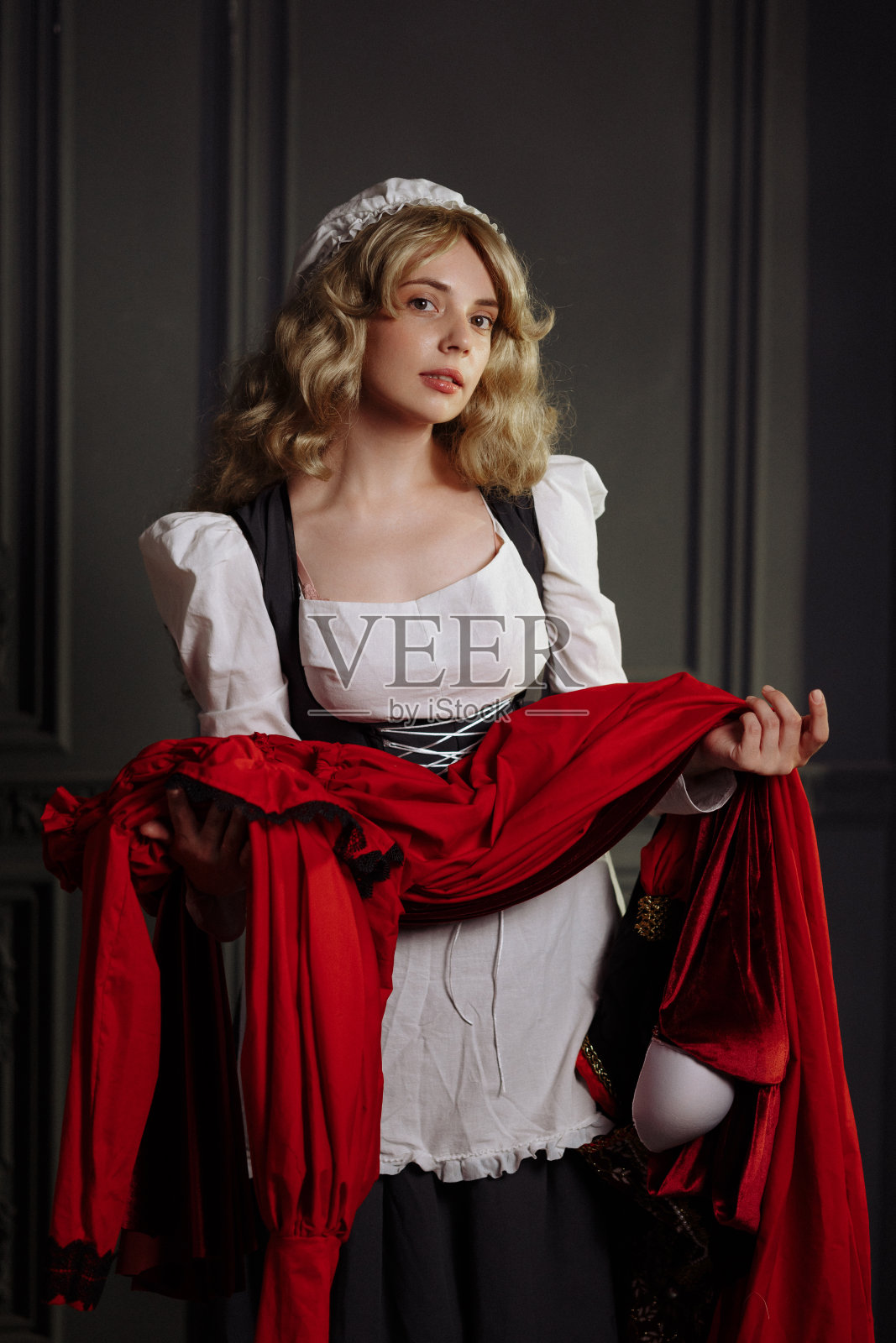 穿着复古连衣裙的中世纪女裁缝。照片摄影图片