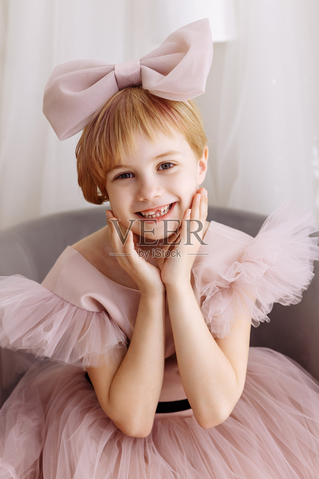 一个7-8岁的女孩，穿着一件艳丽的浅粉色蕾丝连衣裙照片摄影图片