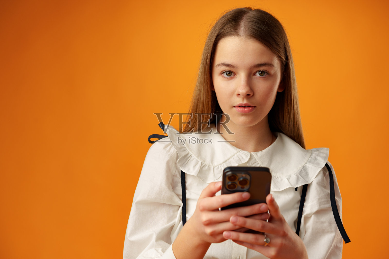 时尚少女在工作室使用黄色背景的智能手机照片摄影图片