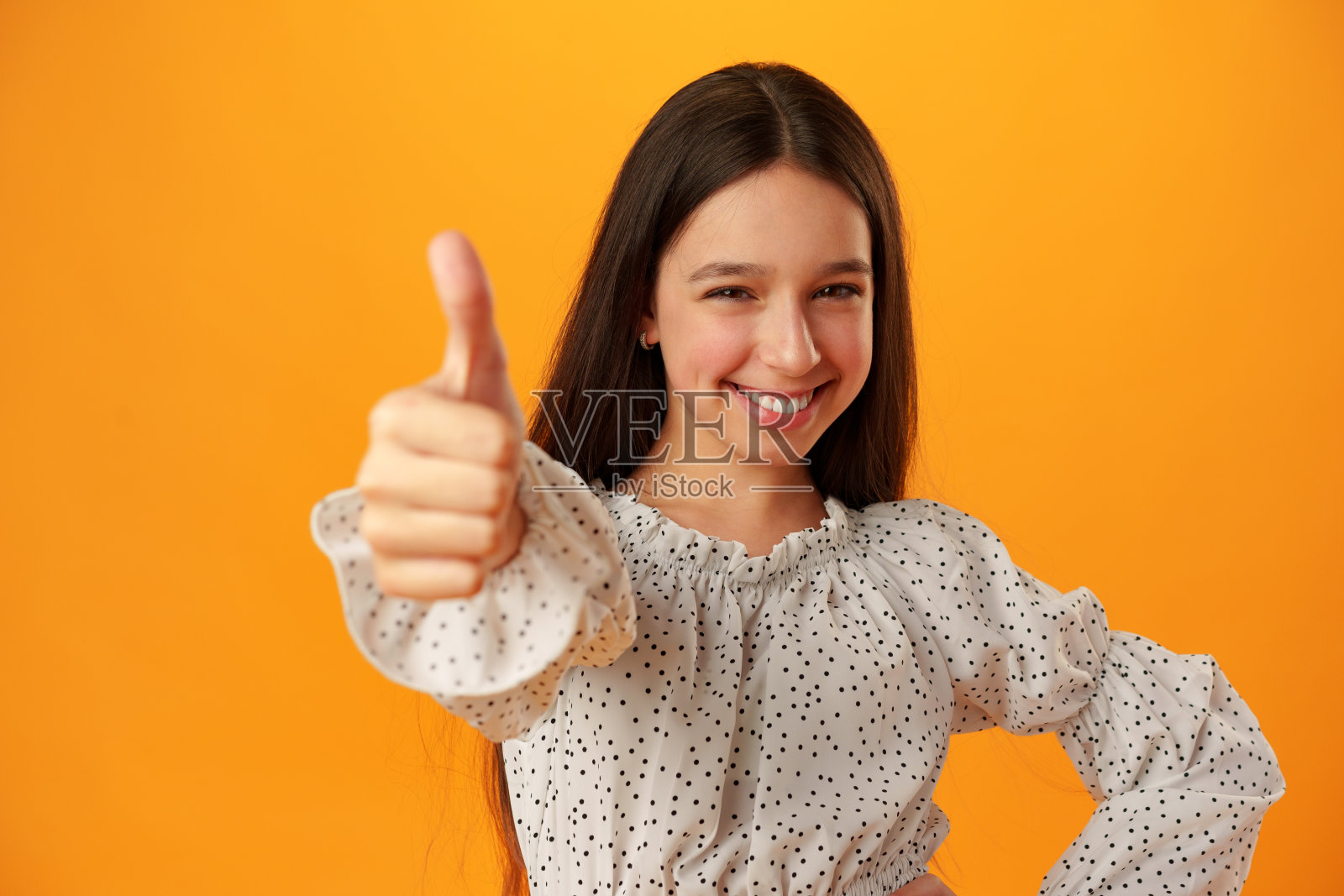 微笑的少女在黄色背景下展示ok的标志照片摄影图片