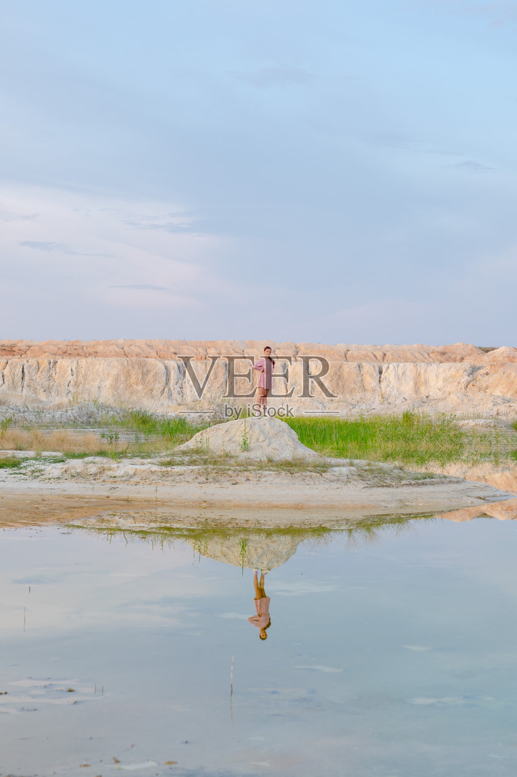 晚上，一个十几岁的女孩穿着漂亮的衣服站在山间的湖边照片摄影图片