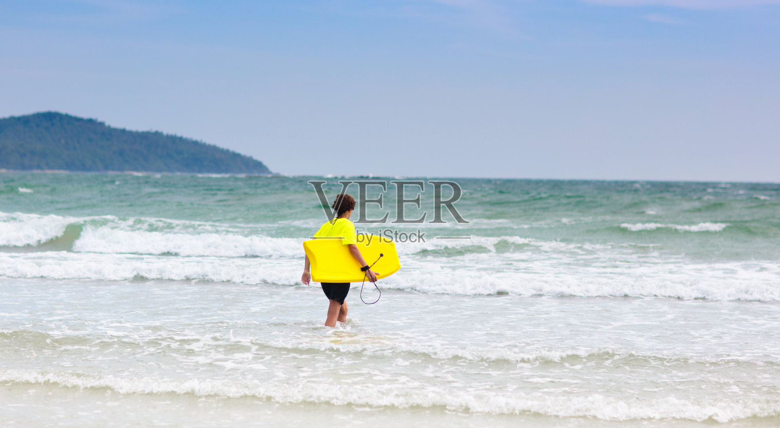 热带海滩上的冲浪者。男孩冲浪。照片摄影图片