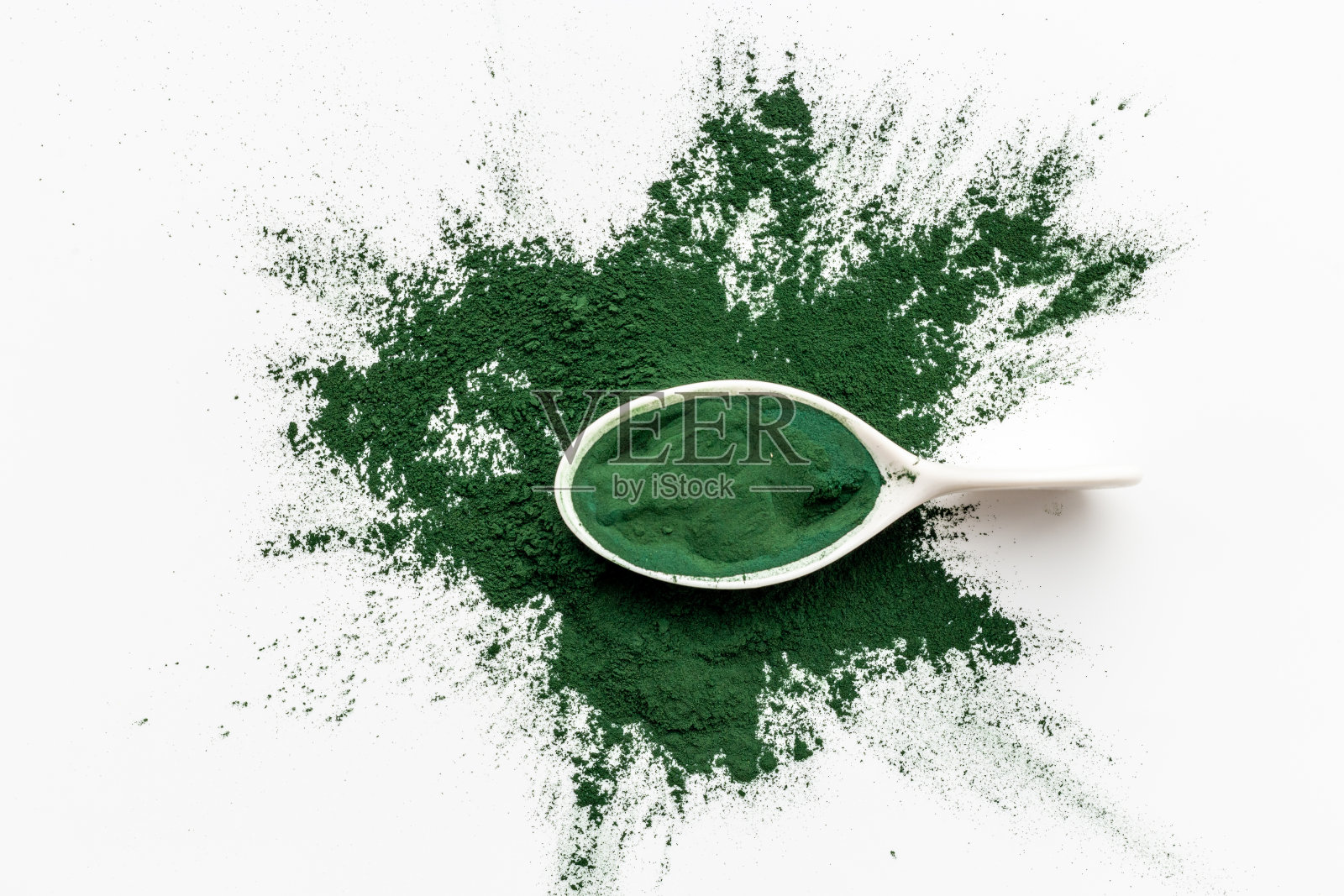 白色背景上的螺旋藻粉末飞溅，俯视图照片摄影图片