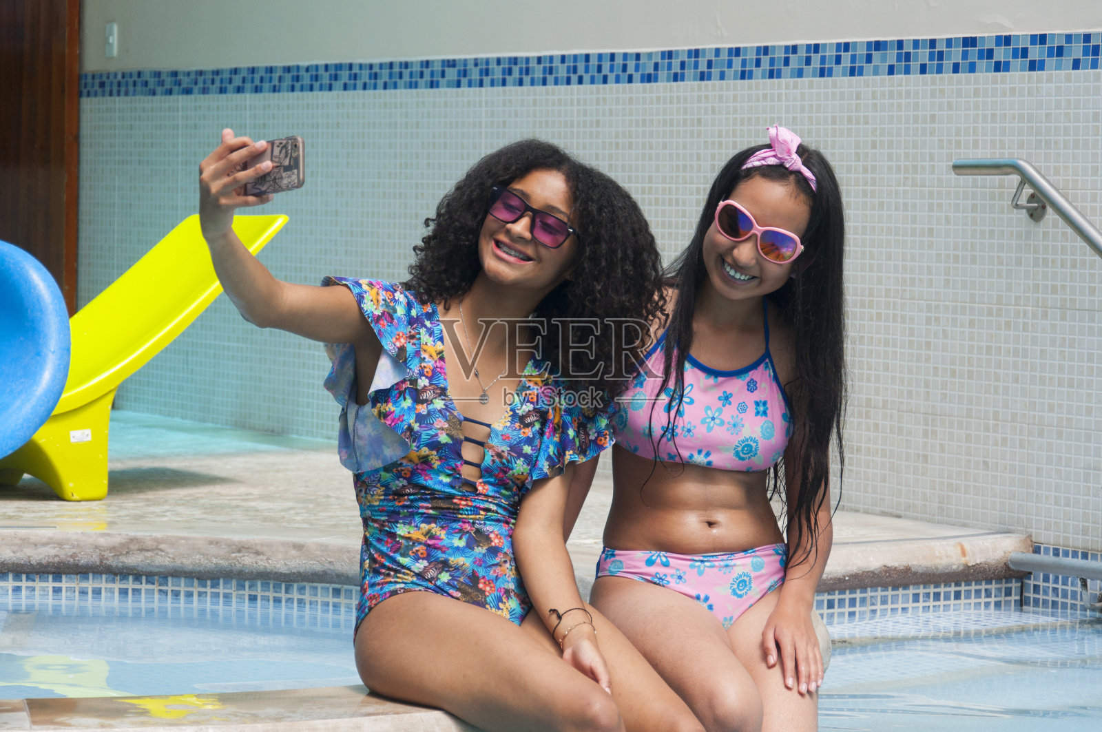 两个朋友在度假胜地观光，一边自拍，一边笑得很开心。旅游日照片摄影图片