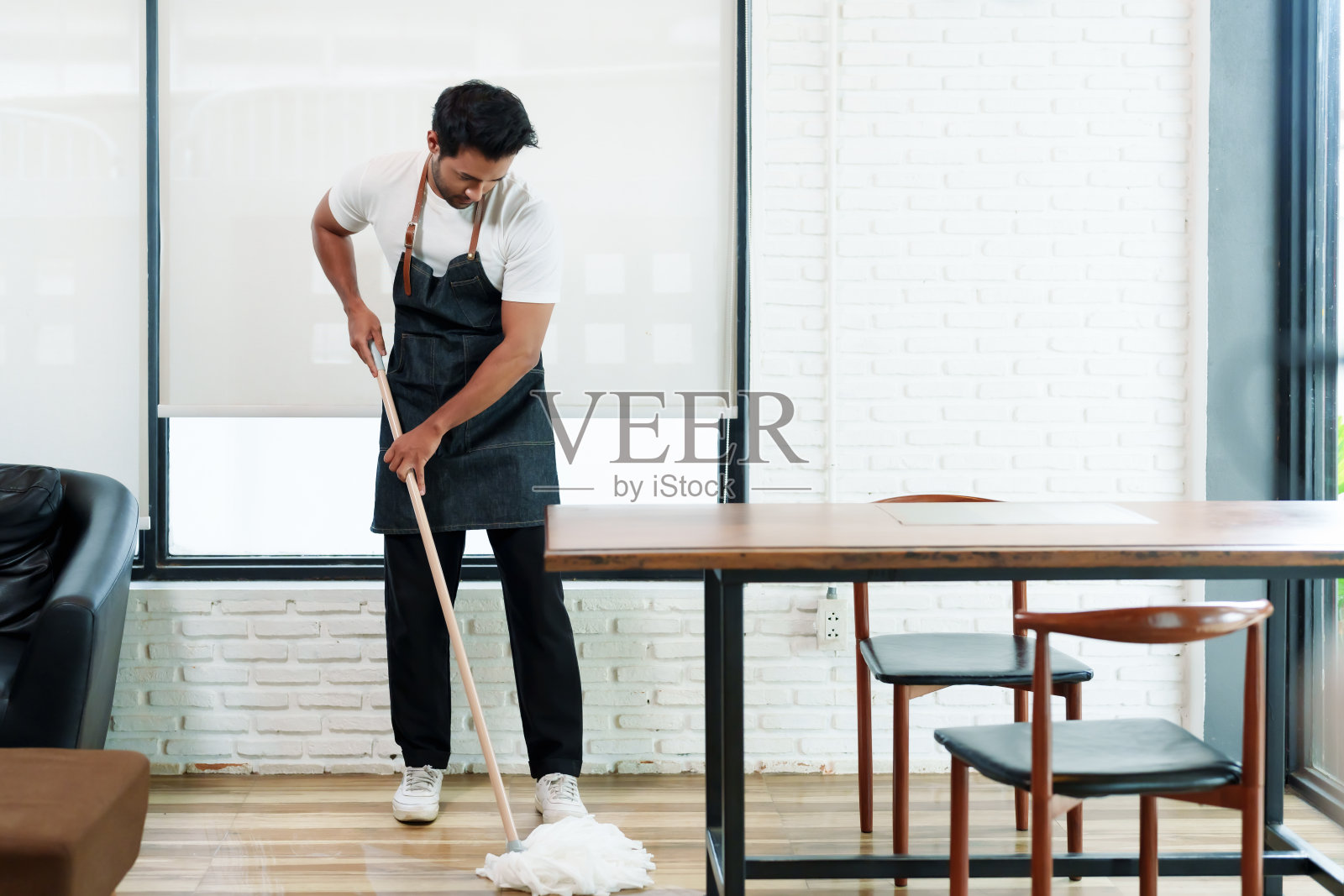 帅气的印度咖啡店工作人员在打烊后拖地。小型企业，家庭餐厅和咖啡店。准备好支持客户第二天使用该服务照片摄影图片