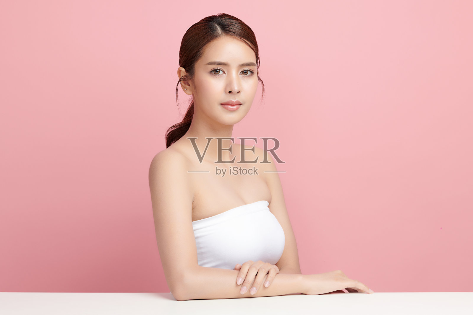 美丽的年轻亚洲女性干净新鲜的皮肤在粉红色的背景，面部护理，面部护理，美容，美容和水疗，亚洲女性肖像。照片摄影图片