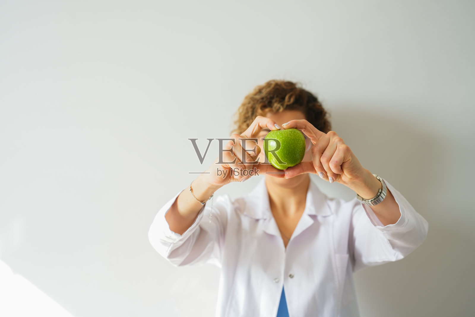 女性健康营养师用苹果做心脏。健康的生活方式照片摄影图片