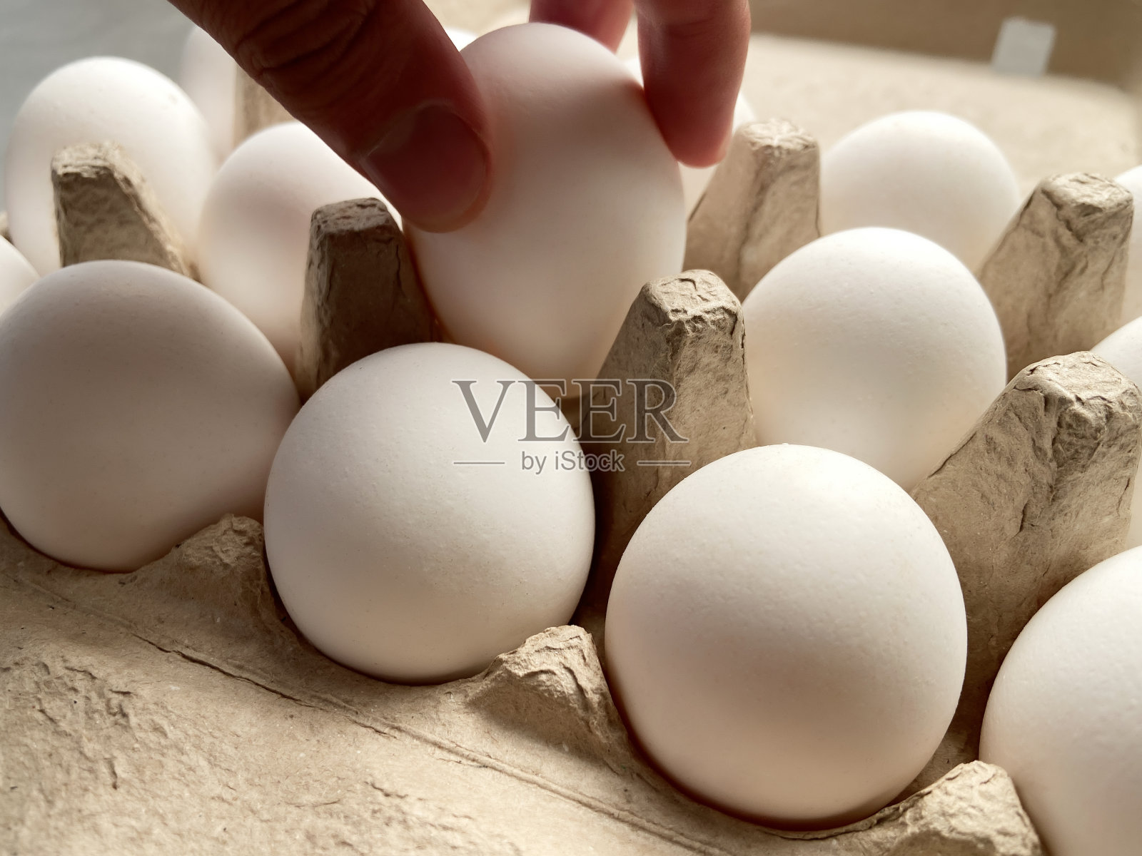 手拿鸡蛋盒里的鸡蛋照片摄影图片