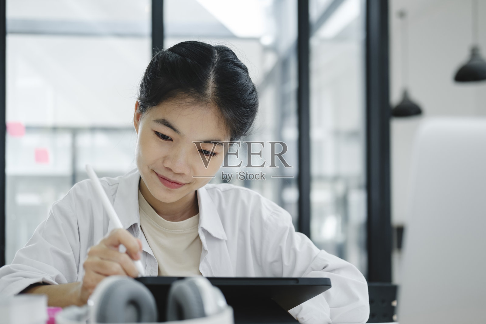 年轻的大学生使用电脑和移动设备在线学习。照片摄影图片