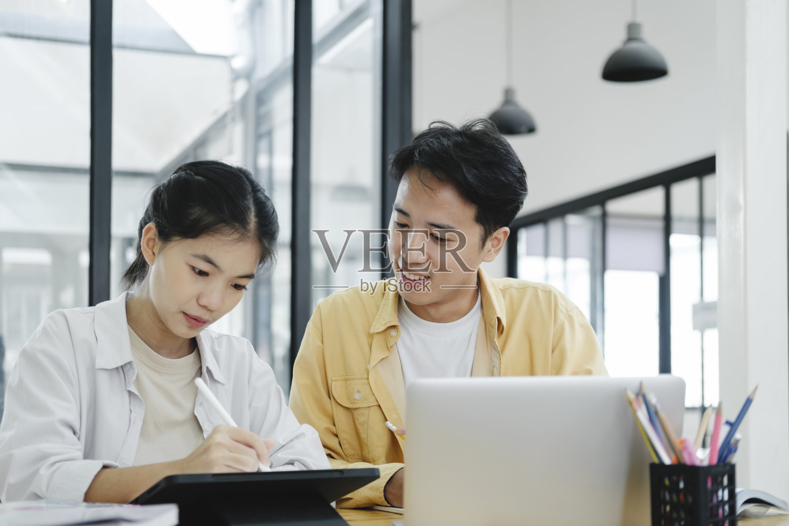 年轻的学生校园帮助朋友赶上和学习。照片摄影图片