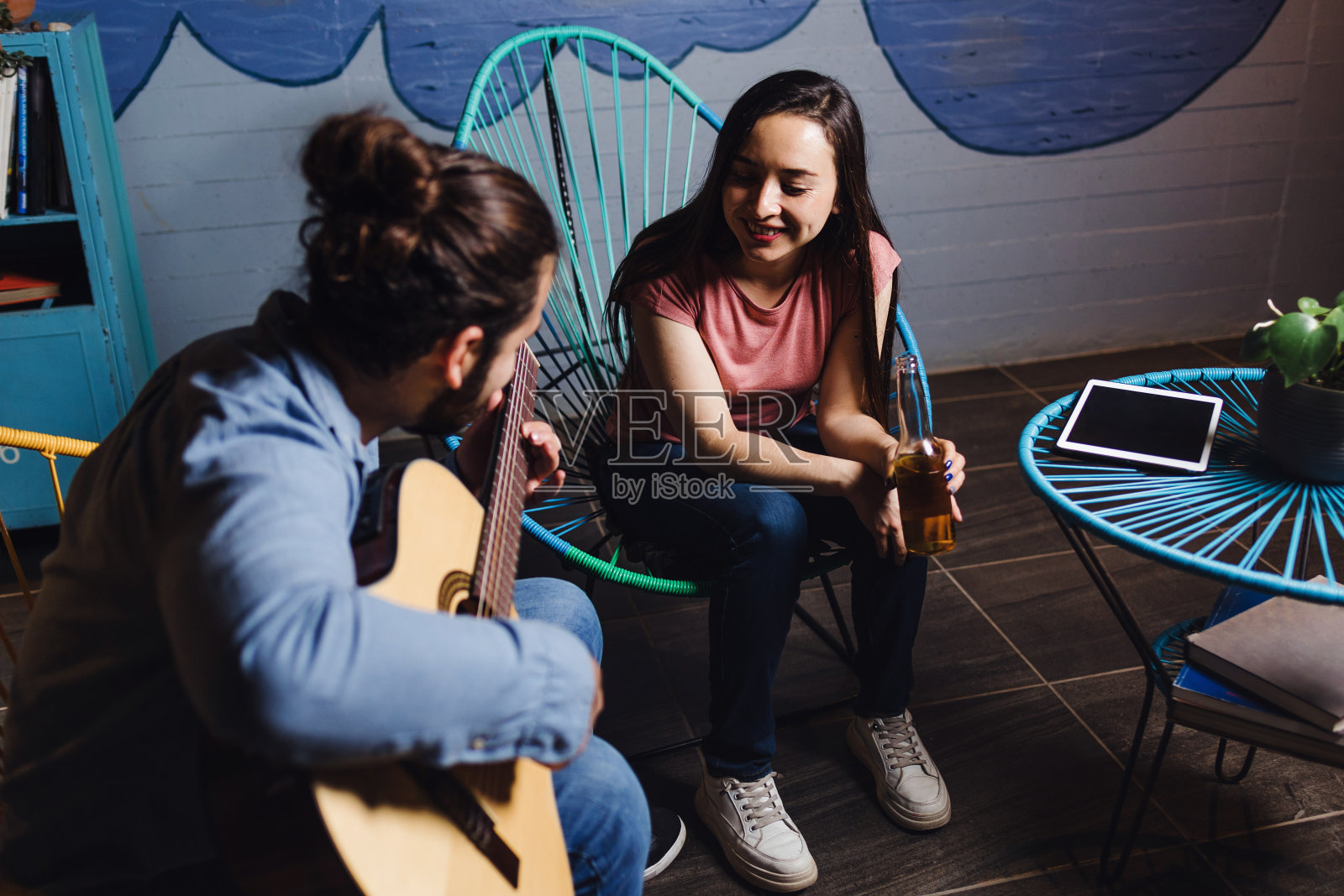 年轻的拉丁夫妇在一个浪漫的约会弹吉他，女朋友和男朋友在家里唱歌在墨西哥拉丁美洲的夜晚，西班牙人照片摄影图片