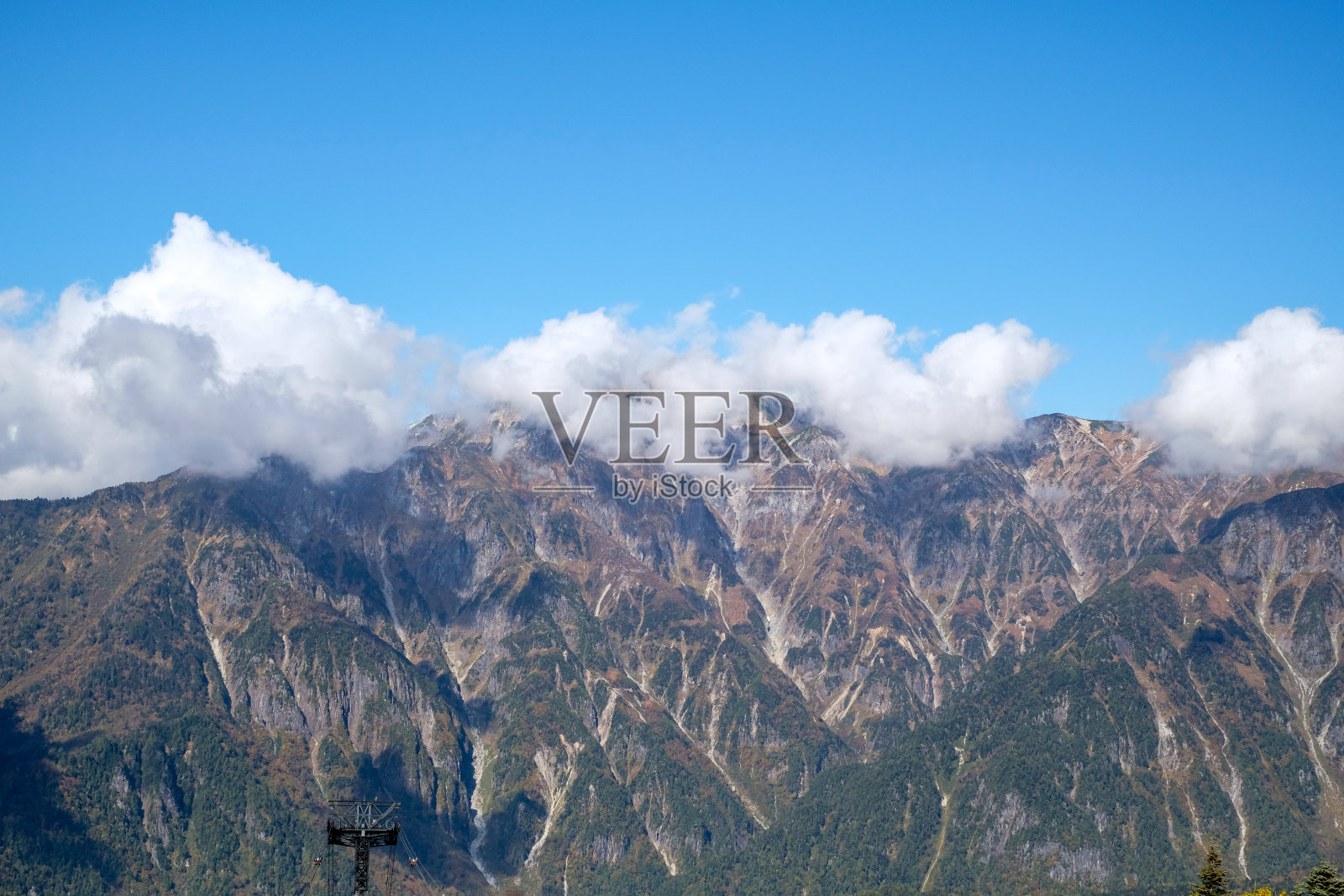 以缆车和索道为游客服务的主要旅游景点新堀田的秋色氛围。阿尔卑斯山脉、新贺高索道和秋天的树叶。照片摄影图片