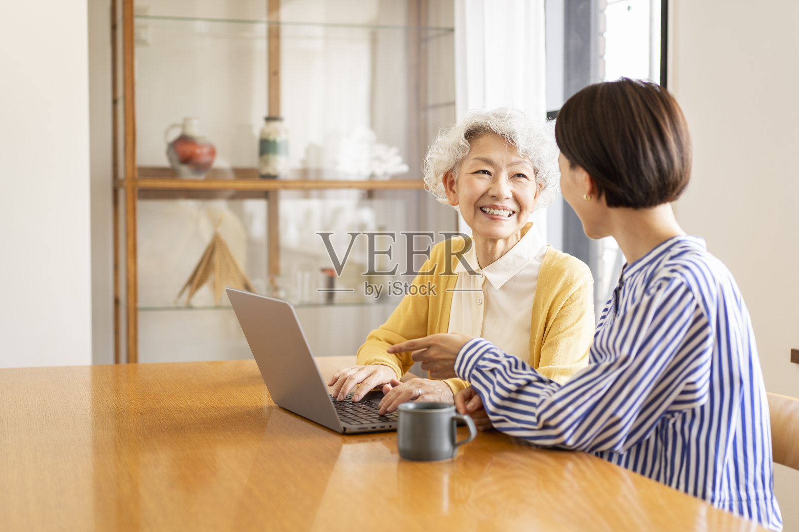 两个亚洲女人在一起看笔记本电脑。照片摄影图片