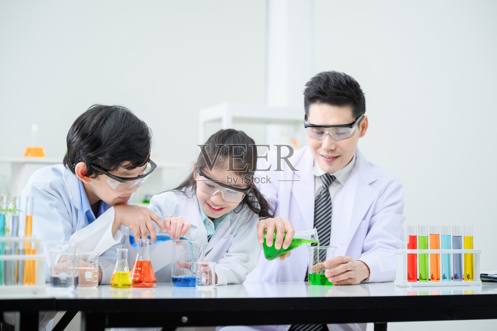 男女学生和老师一起在工作室里学习试管。照片摄影图片