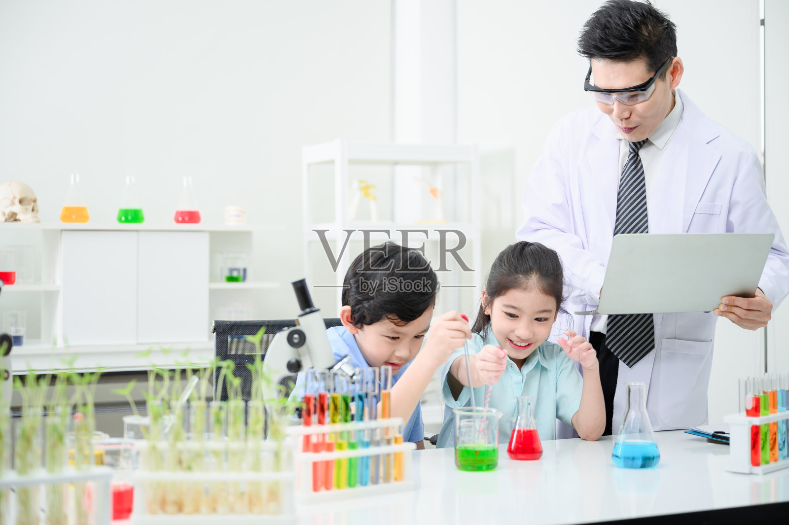 男女学生和老师一起在工作室里学习试管。有趣地学习照片摄影图片