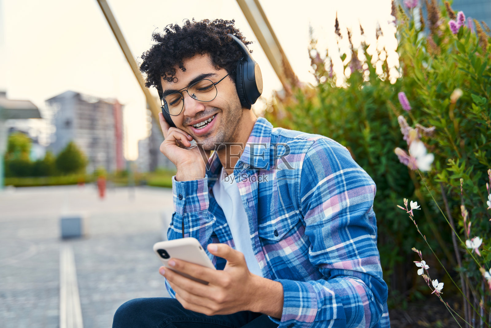 积极的中东人拿着手机在户外听音乐照片摄影图片