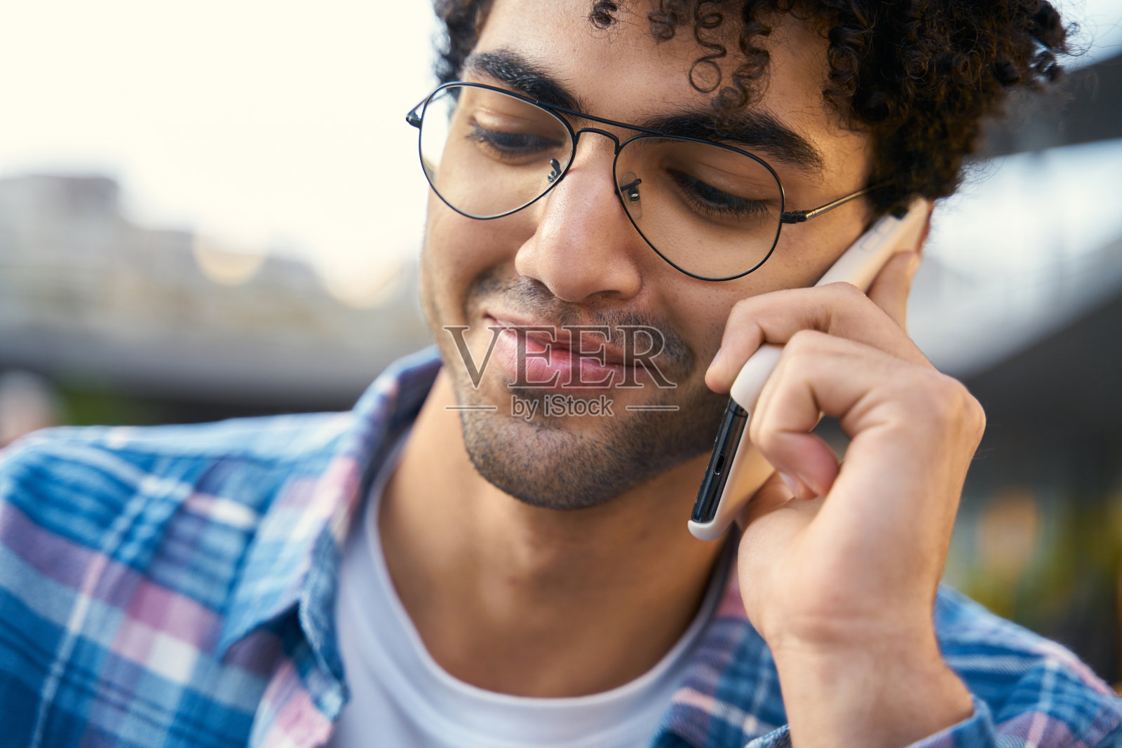 微笑着的埃及男子正在用手机交谈，选择性地集中注意力照片摄影图片