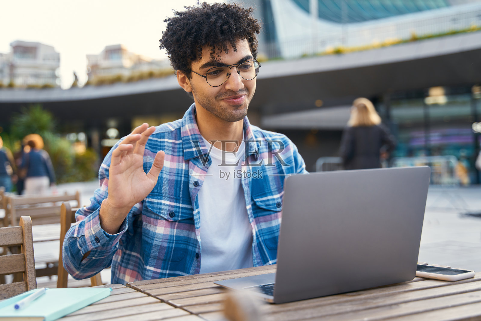 一名埃及男子用笔记本电脑进行视频通话，在户外上网工作。沉思的学生照片摄影图片