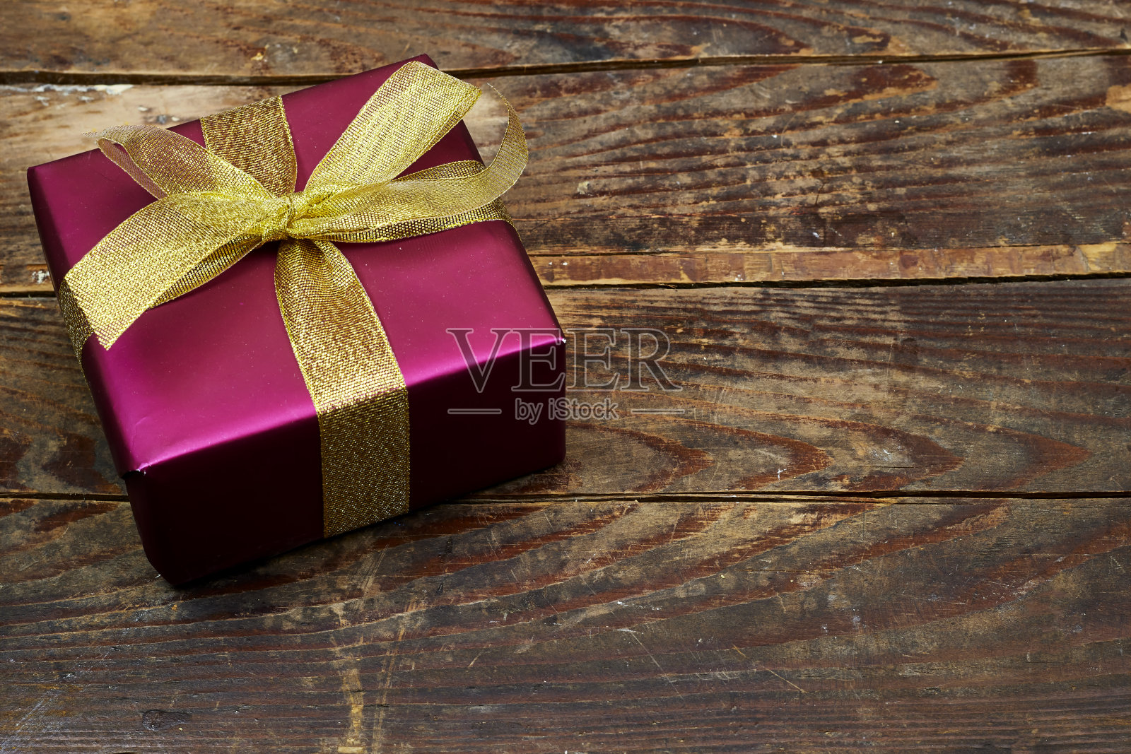粉红色的礼盒与金色丝带在木桌子上。平躺照片摄影图片