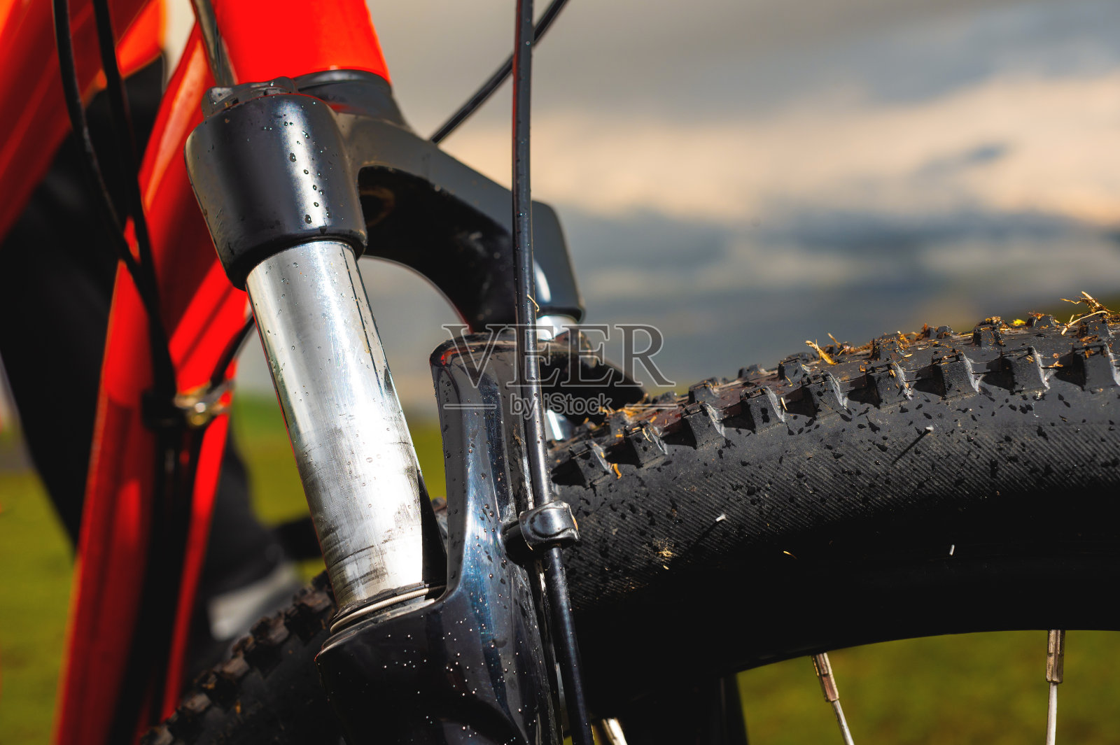 近距离的自行车前悬挂叉与越野山地自行车橡胶户外对夕阳云和山照片摄影图片