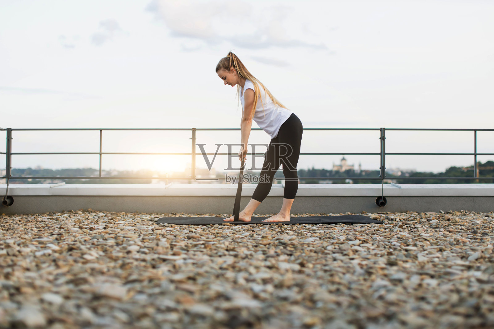 女性在户外的垫子上锻炼伸展带照片摄影图片