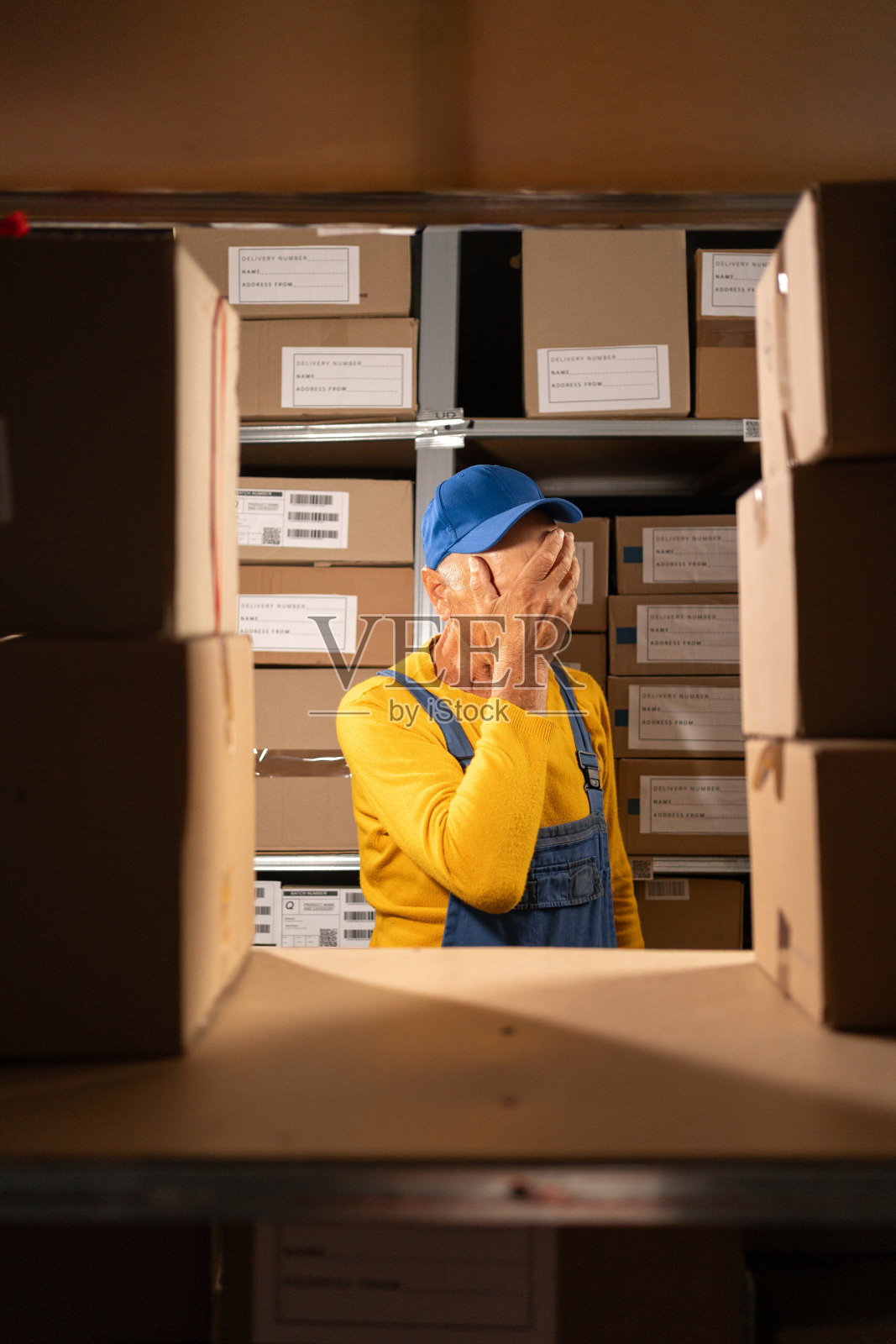 疲惫、筋疲力尽的仓库老年工人有库存问题，感到沮丧，在储藏室里很懒惰照片摄影图片