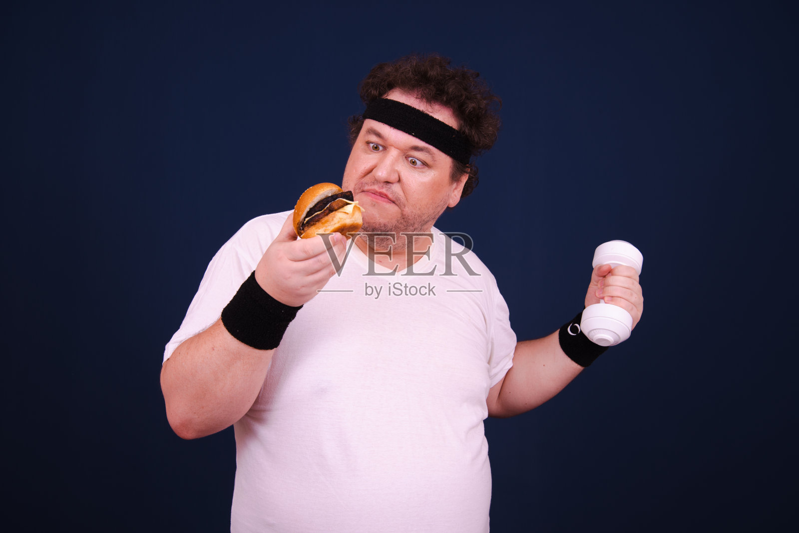 吃汉堡，在健身房健身的滑稽胖子。照片摄影图片