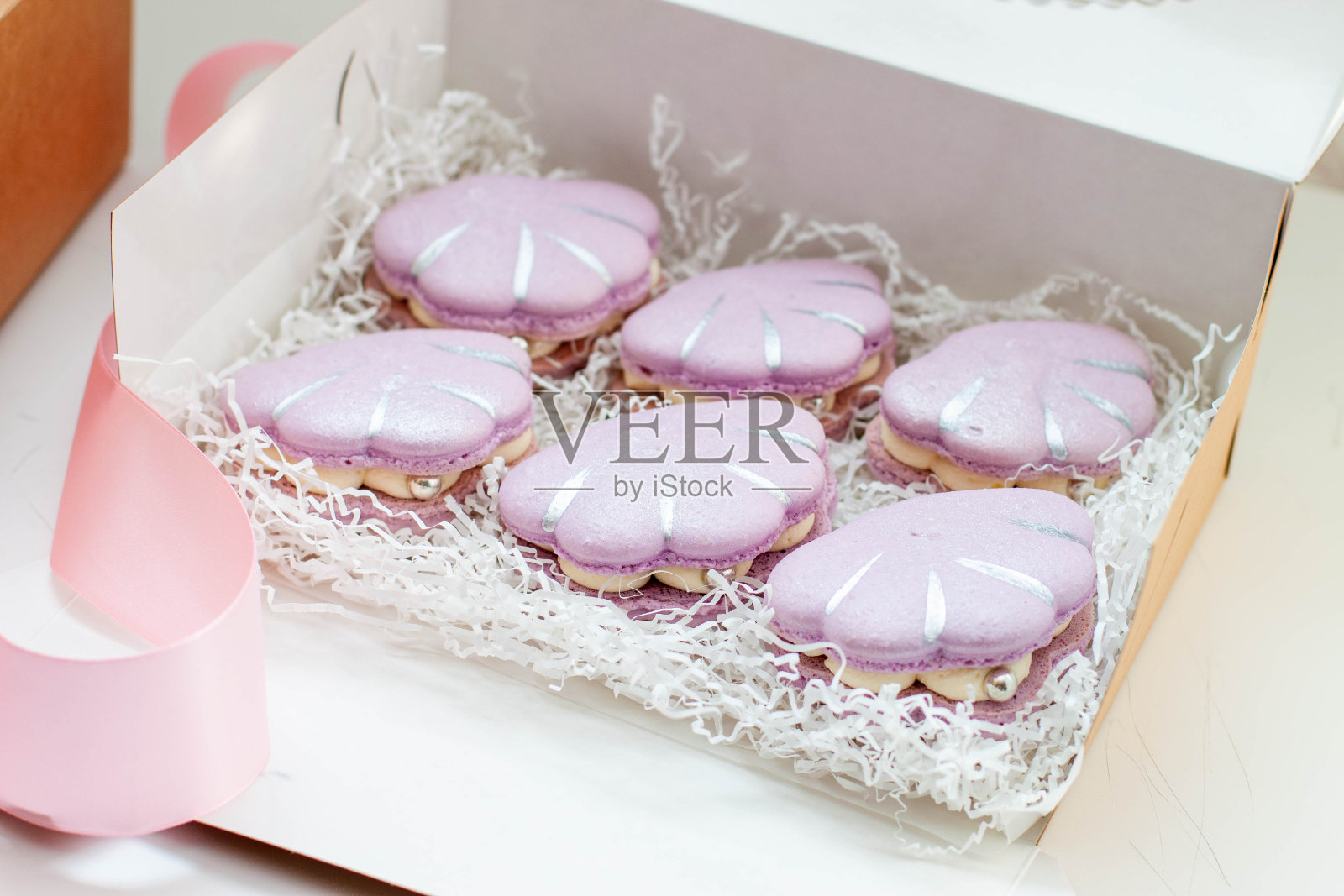 礼盒里的贝壳形状的法国马卡龙，颜色是柔和柔和的紫色照片摄影图片